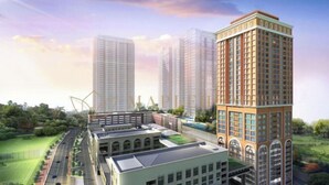 A modern high-rise building with multiple floors, surrounded by greenery and a sports field. - EduSentral Premier Suites Setia Alam (Shah Alam)
