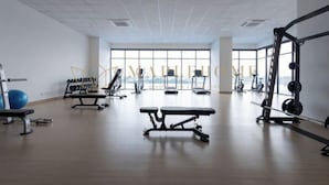 A gym with exercise equipment, a bench, and a large window. - EduSentral Premier Suites Setia Alam (Shah Alam)