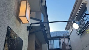 Een smalle, openbare gang met een lamp en een wandlamp.