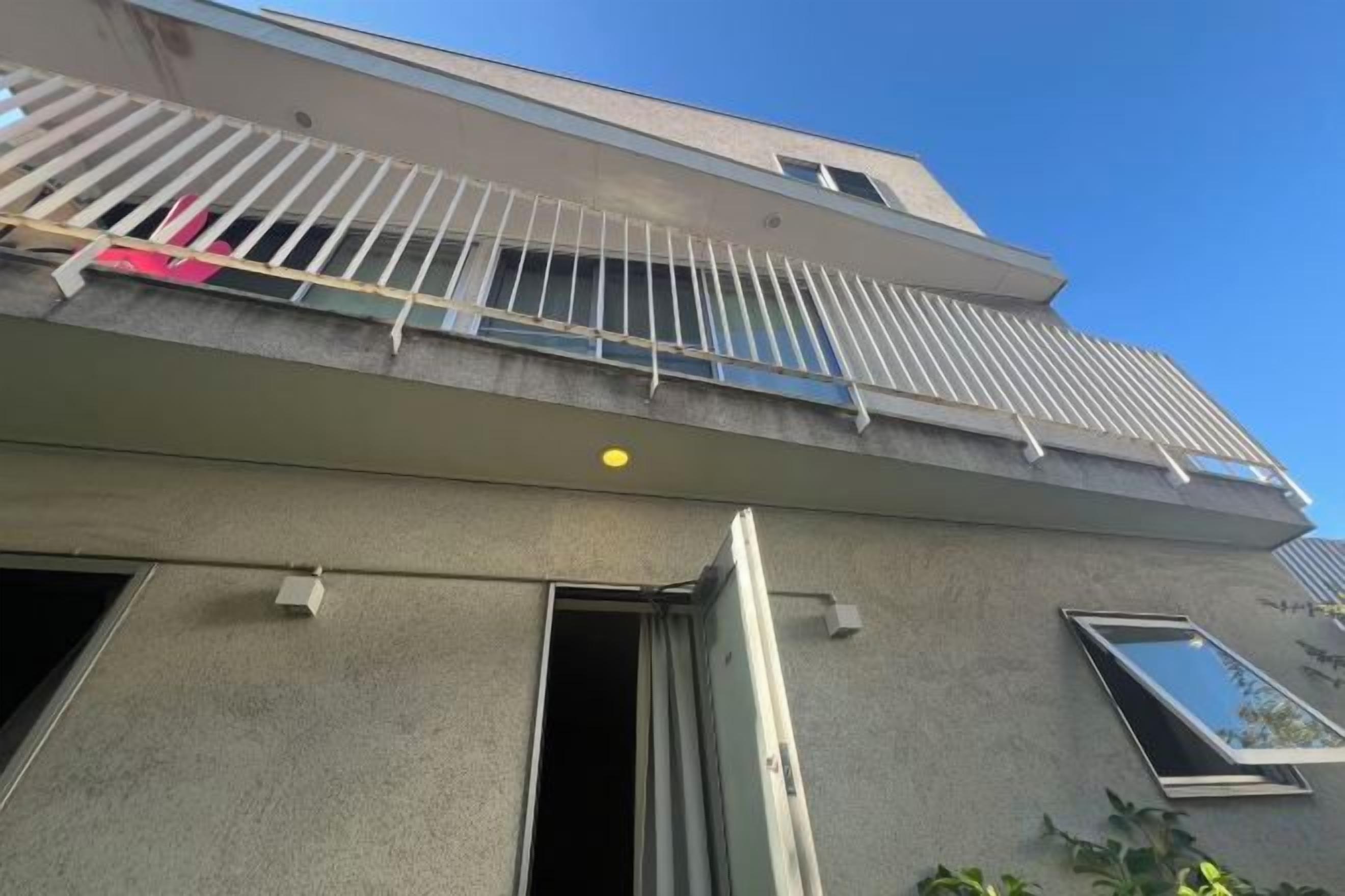 A building with a balcony, a door, and a window.