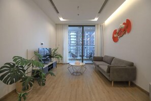 A living room with a sofa, a coffee table, and a TV. - Vinhomes Metropolis Apartment - Comfort Stay Ha Noi (Hanoi)