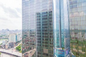A high-rise building with a glass facade, multiple floors, and a cityscape in the background. - Vinhomes Metropolis Apartment - Comfort Stay Ha Noi (Hanoi)