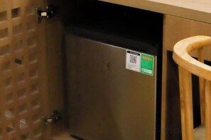 Un electrodoméstico de acero inoxidable, posiblemente un lavavajillas, con un adhesivo con código QR.