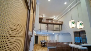 A hotel interior with a wooden floor, a reception desk, a staircase, and hanging lanterns. - KATOYA SUITES SAIGON HONKAN (Ho Chi Minh City)