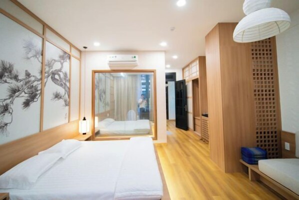 Una habitación de hotel con una cama, una mesita de noche, un espejo y suelo de madera.
