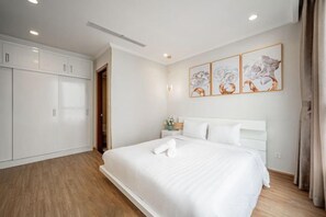Une chambre d’hôtel avec un grand lit, une armoire et des œuvres d’art accrochées au mur.