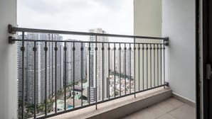Een balkon met een metalen hekwerk met uitzicht op een stadsgezicht.