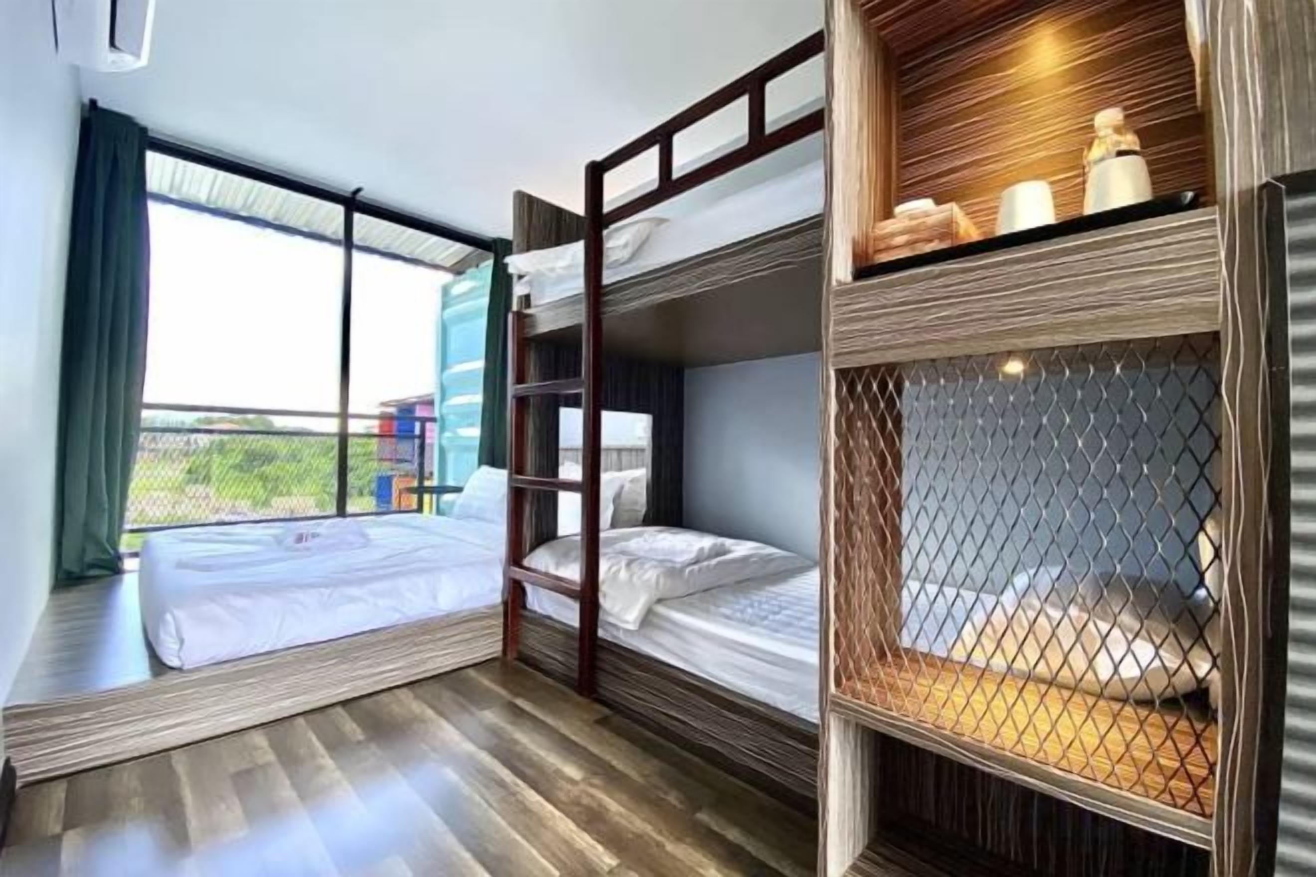 A room with bunk beds, a window with a view, and a shelf with toiletries.
