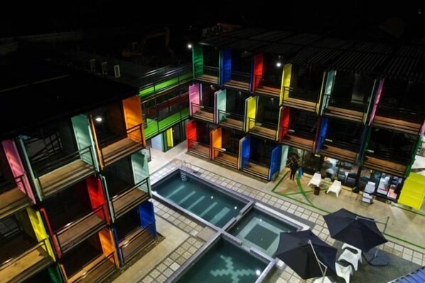 A multi-story hotel with balconies, a swimming pool, and outdoor seating areas. - BOX INN SEMPORNA (Semporna)