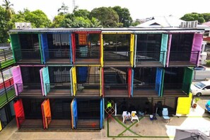 A multi-story building with balconies and a ground-level area with tables and chairs. - BOX INN SEMPORNA (Semporna)