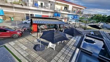 A rooftop patio with outdoor seating, a covered area, and a swimming pool.