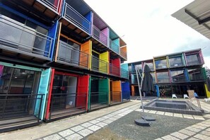 Un edificio de varios pisos con balcones y un área de estar al aire libre techada.