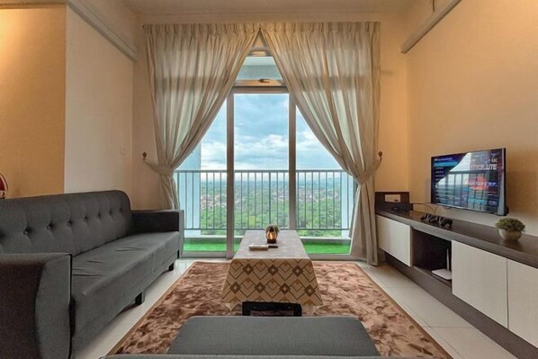 A living room with a sofa, a coffee table, and a TV on a stand.