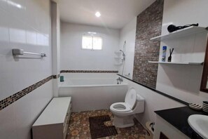 A bathroom with a bathtub, toilet, and sink. - Jacuzzi Pool Villa (Pattaya)