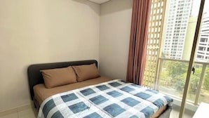 A bedroom with a bed, a window with a view of buildings, and a curtain. - Super Cozy and Clean Apartment connected to mall (West Jakarta)