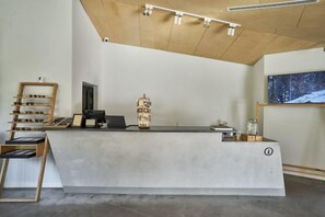 Un mostrador de recepción de diseño moderno, techo de madera y una obra de arte enmarcada en la pared.