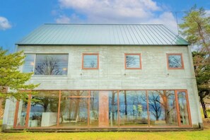 A two-story building with a metal roof, large windows, and a glass facade. - Toyako Villa Susukian (Usu District)