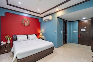 Une chambre à coucher avec un lit, une table de chevet, une lampe et des éléments de décoration murale.