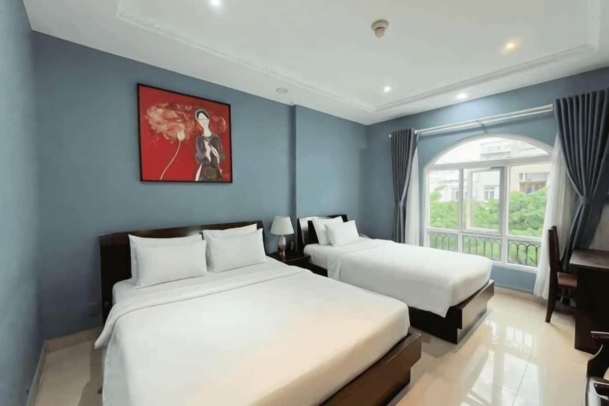 A hotel room with two beds, a large window with a view, and a painting on the wall.