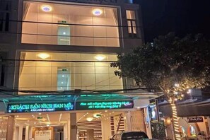 Un hôtel doté d’une façade moderne, d’une enseigne lumineuse et d’une entrée bien visible.