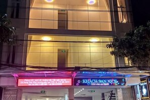 Un bâtiment doté d’une grande entrée et d ’une enseigne indiquant « KHACH SANG NICE ».