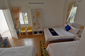 Une chambre avec deux lits, un banc et une fenêtre avec des rideaux.