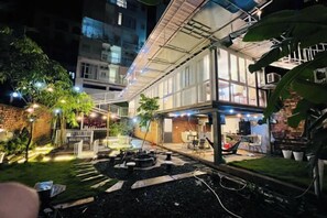 Une cour dotée d’un espace salon abrité, de mobilier d’extérieur et d’un petit jardin.