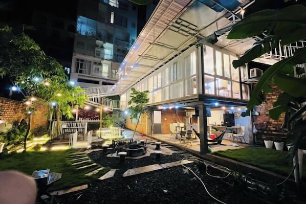 A courtyard with a covered seating area, outdoor furniture, and a small garden.