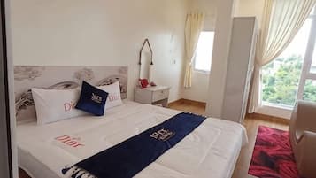 A hotel room with a bed, nightstand, and a window with curtains.