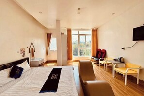 A hotel room with a bed, a desk, a chair, a TV, and a window with curtains. - Nice Hotel Buon Ma Thuot (Tu An)