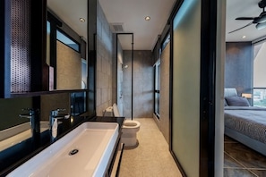 Un baño moderno con un lavabo grande, inodoro y zona de ducha.