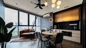 A modern kitchen with a dining area, large windows, and a ceiling fan.