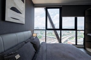 A modern hotel room with a large bed, a city view, and a contemporary design. - SCARLETZ BY FEEL HOME (Kuala Lumpur)