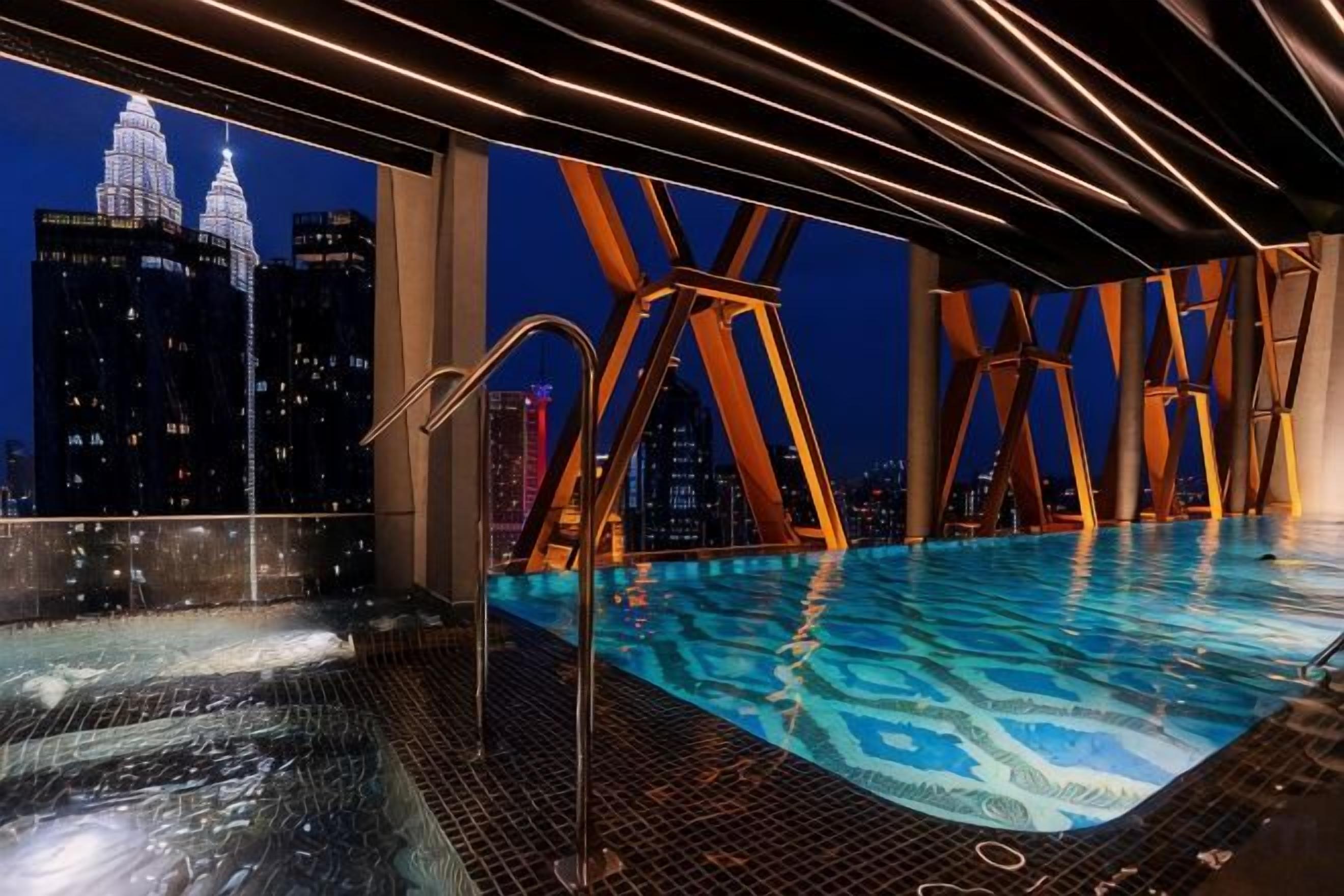 A rooftop infinity pool with a city view, including a prominent building with two towers.