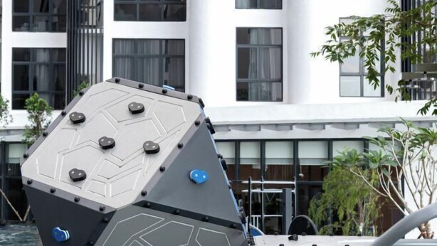 A hexagonal, metallic structure with bolts, possibly a part of a building or installation, in front of a modern white building with large windows and a balcony. - Grace Suite @ The Shore Kota Kinabalu (Kota Kinabalu)