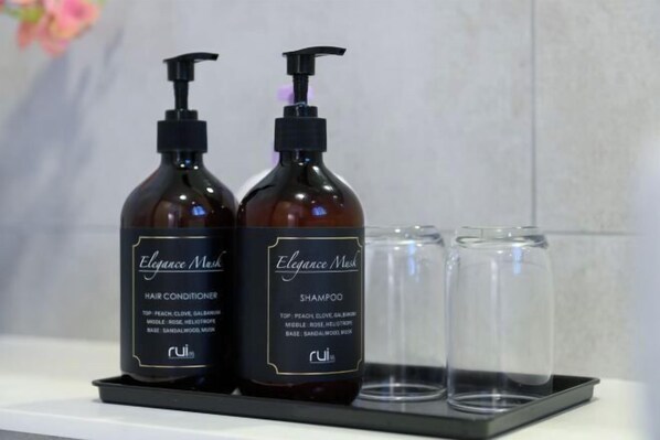 Two bottles of Elegance Musk hair conditioner and shampoo, and two empty glass bottles on a tray. - Grace Suite @ The Shore Kota Kinabalu (Kota Kinabalu)