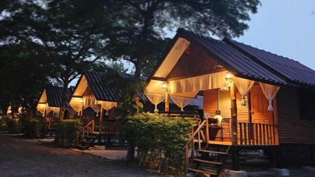 A row of wooden cabins with balconies, each featuring a small porch and a lamp. - Ingnaam Thajeen (Si Prachan)