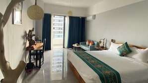 Camera d'albergo con un letto, una scrivania, una sedia, un tavolo da pranzo e vista all'esterno.