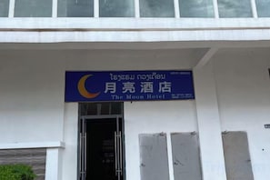 A hotel sign with a crescent moon and the name 'The Moon Hotel' in both Thai and English. - THE MOON HOTEL (Boten)