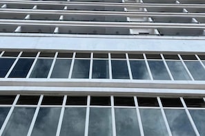 A building facade with multiple windows and a central air conditioning unit. - THE MOON HOTEL (Boten)