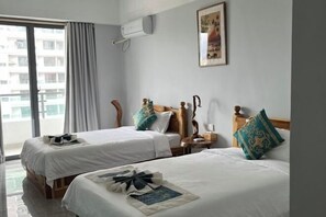 A hotel room with two beds, a window with curtains, a wall-mounted air conditioner, and a framed picture. - THE MOON HOTEL (Boten)