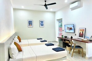 A hotel room with two beds, a desk, a chair, and a ceiling fan. - SKY VILLA - BKK Central Phnom Penh - Rooms and Apartments (Phnom Penh)