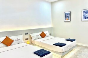 Een hotelkamer met twee bedden, een groot raam en kunst aan de wanden.