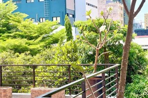 A staircase with a metal railing, surrounded by greenery and buildings in the background. - SKY VILLA - BKK Central Phnom Penh - Rooms and Apartments (Phnom Penh)