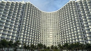 A large, curved hotel building with numerous balconies and a uniform exterior. - The Cam Ranh Oceanview (Cam Ranh)