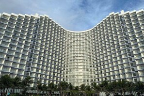 A large hotel with a curved facade, multiple balconies, and a clear sky. - The Cam Ranh Oceanview (Cam Ranh)