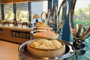 Un buffet proposant divers plats présentés dans des plats de service ronds en acier inoxydable.