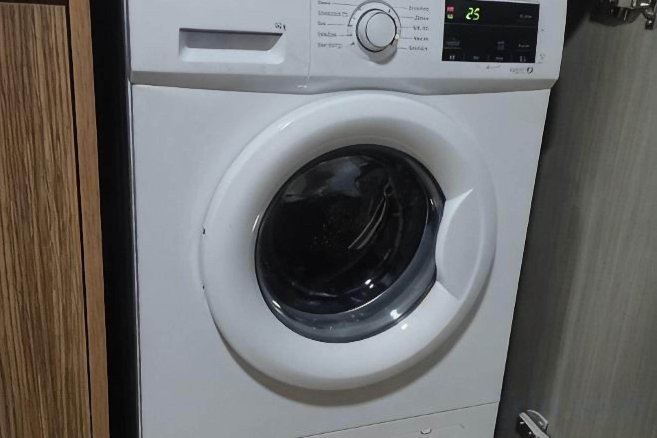A front view of a front-loading washing machine with a digital control panel.