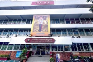 A police station building with a banner, multiple windows, and a sign indicating its purpose. - uouRangnamHouse (Bangkok)