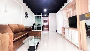 A modern living room with a sofa, coffee table, and TV stand. - uouRangnamHouse (Bangkok)